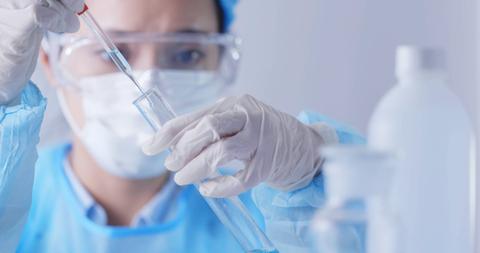 Un profesional de la salud está usando una pipeta para medir un líquido en un laboratorio.