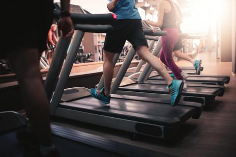 Algunas personas corriendo en cintas de correr en un gimnasio.