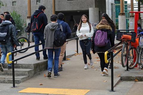 Un grupo de estudiantes se mueve por un campus universitario durante el día.