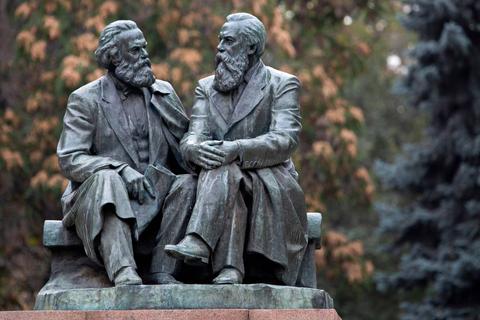 Estatua de dos pensadores conversando en un parque.