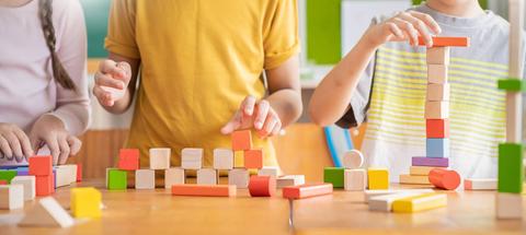 Niños jugando con bloques de construcción en una mesa.