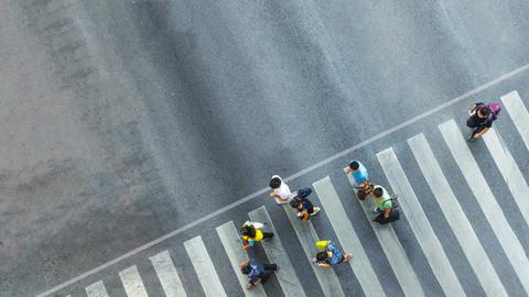 Un grupo de personas cruza una calle en un paso peatonal.