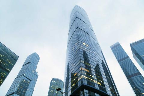 Imagen de rascacielos de cristal en un día nublado.