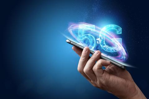 Una mano sostiene un teléfono móvil que muestra un efecto visual de 5G.