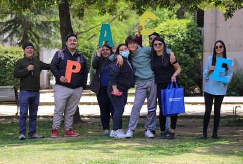 Un grupo de personas en un parque sostiene letras que forman la palabra 'Paz'.