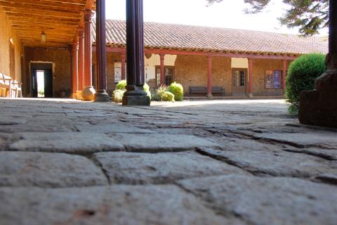 Vista del patio de una construcción con columnas y suelo de piedra.