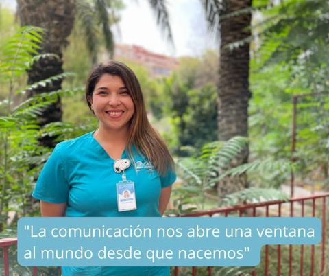 Mujer sonriente con camiseta azul en un entorno natural de plantas.