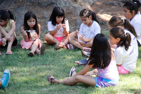 Un grupo de niñas sentadas en el césped, disfrutando de un momento juntas.