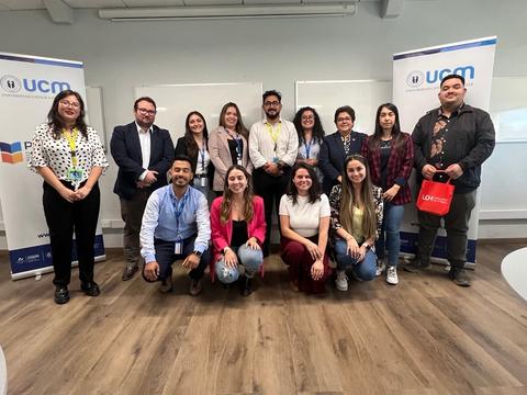 Grupo de personas posando juntas en un evento en una institución educativa.