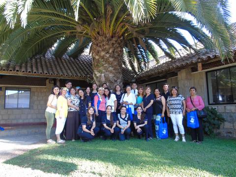 Un grupo de personas posando frente a una palmera en un entorno al aire libre.