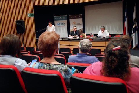 Una reunión con un panel de ponentes y una audiencia sentada en un auditorio.