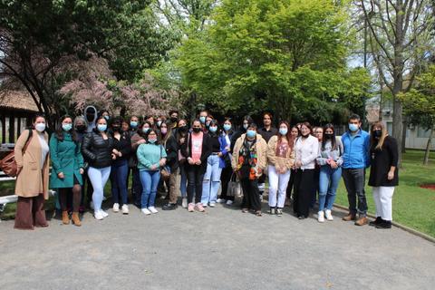 Grupo de personas posando juntas al aire libre, con mascarillas y rodeados de vegetación.