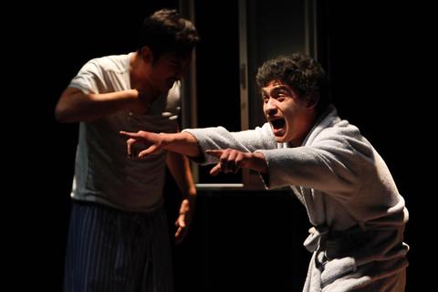 Dos hombres en un momento de conflicto, uno gritando y el otro luciendo inquieto.