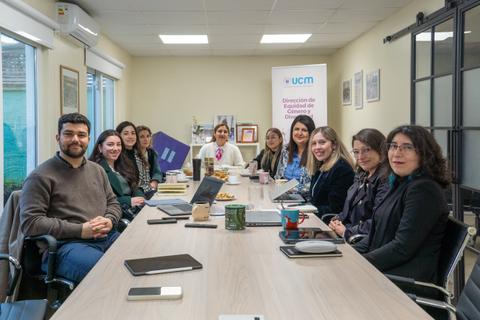 Un grupo de profesionales sentados alrededor de una mesa en una reunión de trabajo.