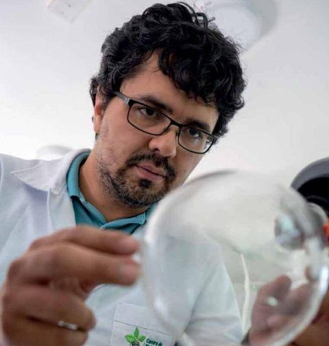 Un hombre con gafas observa atentamente una burbuja en un laboratorio.