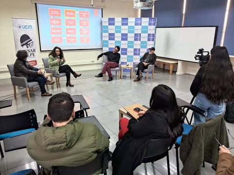 Un panel de discusión con varios participantes en un entorno académico.