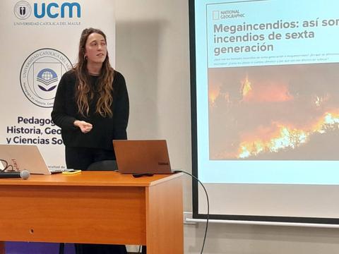 Una mujer presenta sobre megaincendios en un aula universitaria.