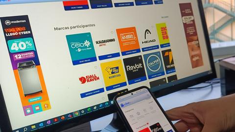 Una persona viendo promociones en un computador y un celular.