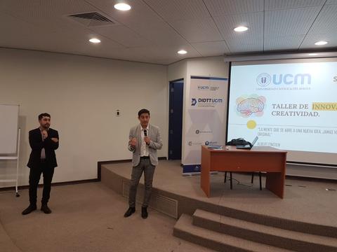 Dos presentadores están en un taller de innovación y creatividad en un auditorio.