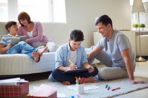 Una familia disfrutando de tiempo juntos en casa, con los niños dibujando y leyendo.