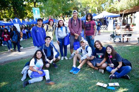 Un grupo de jóvenes posando juntos al aire libre en un ambiente festivo.