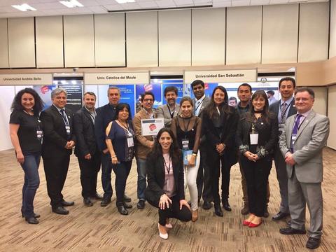 Grupo de personas posando en un evento académico en un recinto cerrado.