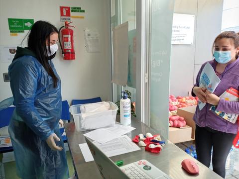 Una trabajadora de la salud interactúa con una mujer en un centro de atención médica.