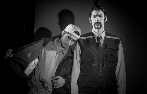 Dos hombres en blanco y negro, uno con gorra y chaqueta, el otro vestido con un chaleco de seguridad.