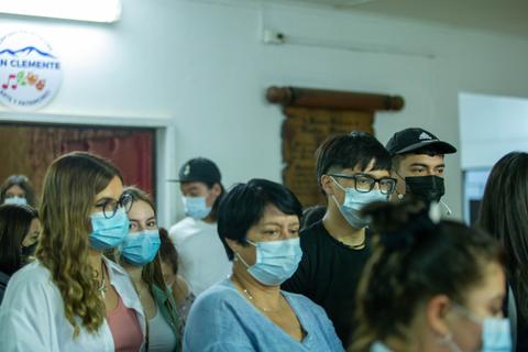 Un grupo de personas usando mascarillas en un espacio cerrado.