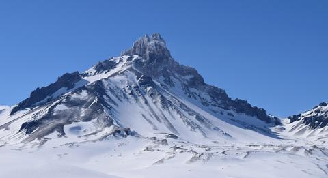 Una majestuosa montaña cubierta de nieve bajo un cielo despejado.