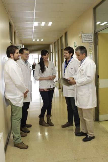 Un grupo de profesionales de la salud discute en un pasillo de un hospital.