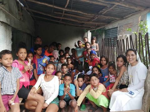 Grupo de niños y adultos en un espacio al aire libre, posando juntos con sonrisas.