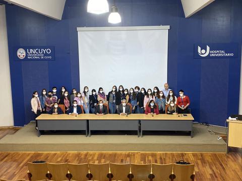 Grupo de estudiantes y profesores posando en un auditorio de la Universidad Nacional de Cuyo.