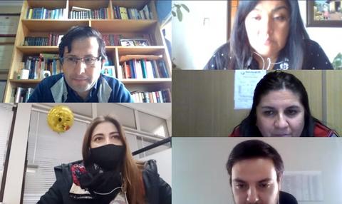 Un grupo de personas participando en una videoconferencia con un ambiente profesional.