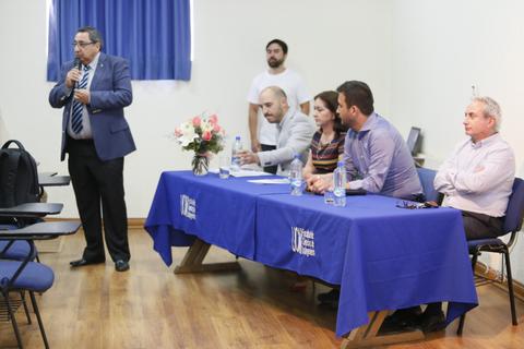 Un grupo de personas en una mesa de panel durante un evento académico.