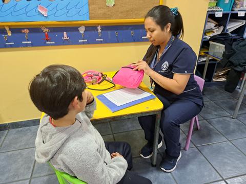 Una persona está atendiendo a un niño en un entorno educativo.