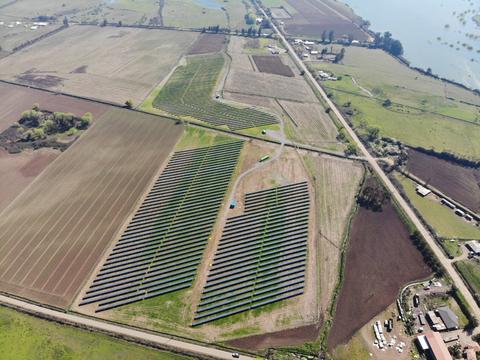 Vista aérea de un campo de paneles solares en un paisaje agrícola.