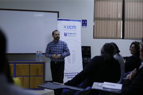 Un hombre está dando una presentación frente a un grupo en un aula.