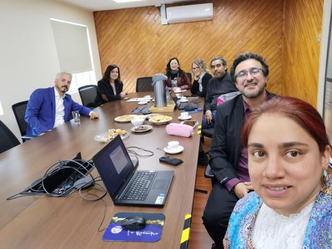 Reunión de un grupo de personas en una sala de conferencias con comida en la mesa.