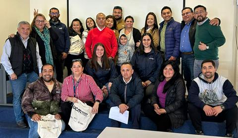 Un grupo de personas sonrientes posa para una foto en un entorno interior.