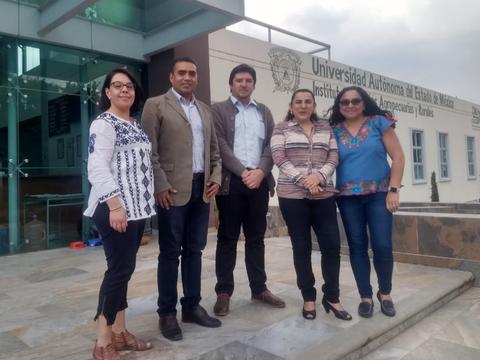 Un grupo de cinco personas posando frente a un edificio de la Universidad Autónoma del Estado de México.