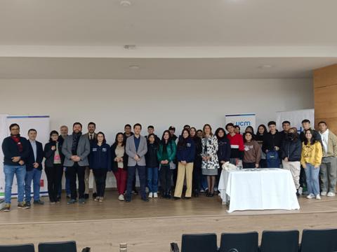 Grupo de personas posando en un evento en un salón.