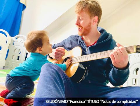 Un adulto toca la guitarra mientras un niño pequeño lo observa con atención.