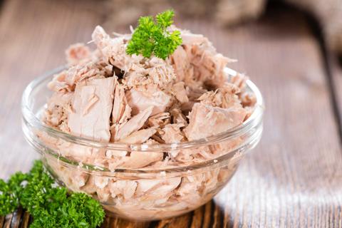 Un tazón de atún desmenuzado con perejil fresco.