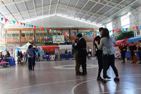 Un grupo de personas bailando en un recinto decorado con banderines de colores.