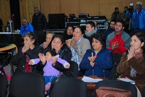 Un grupo de personas aplaudiendo y sonriendo en un evento.