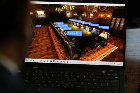 Una reunión virtual en una sala virtual con varios participantes visibles en una pantalla de computadora.