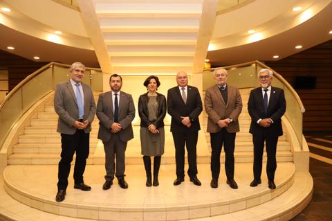 Un grupo de seis personas posando en una escalera elegante en un edificio moderno.