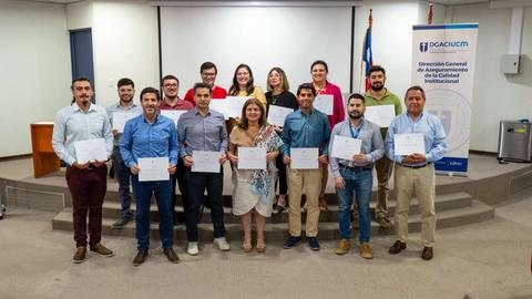Un grupo de personas sostiene certificados en un evento de entrega de premios.