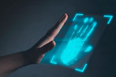 Una mano se proyecta sobre una imagen holográfica de una huella digital azul.